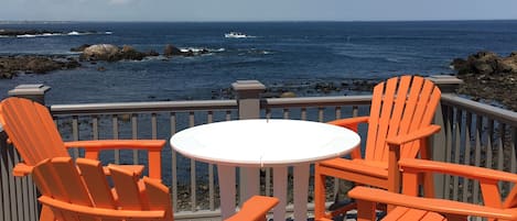 Second floor ocean front deck with adirondack chair seating.