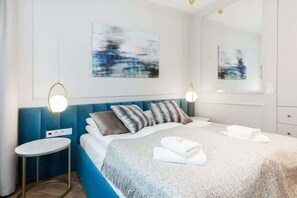 A serene bedroom featuring a soft bed with luxurious bedding, a large window with a city view, and stylish bedside lighting.