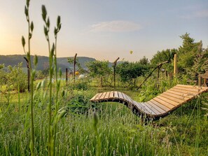 Schwebeliege im Garten, der Blick schweift über die Region Vulkanland Steiermark