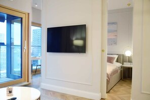 A comfortable living room area with a gray sofa, elegant decor, and large windows that bring in ample natural light.