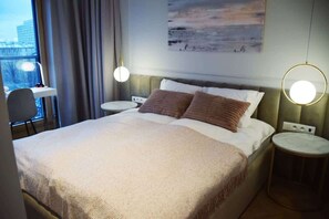 A luxurious bedroom featuring a large, plush bed with soft bedding, warm bedside lighting, and a peaceful, inviting ambiance.