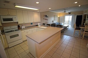 Spacious kitchen, long countertop, 4 stools at counter.
