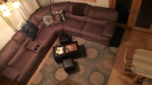 The living area has a large couch and satellite TV, from the loft at night.