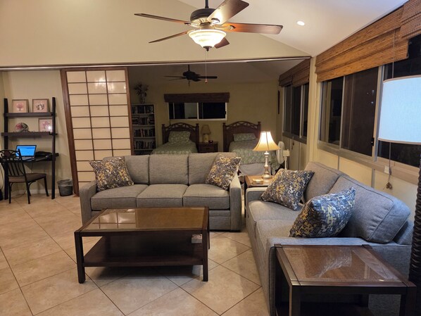 Living room with Queen Sofa bed.  Dedicated work area is in back left of photo.