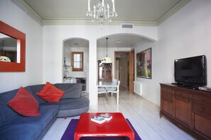Spacious and bright living room with TV and dining area.