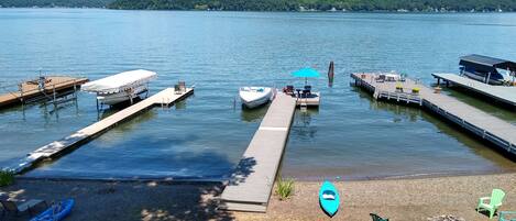 View of beach, fire pit, and dock from porch