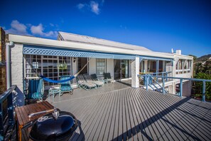 The sundeck featuring loads of outdoor furniture and weber barbecue