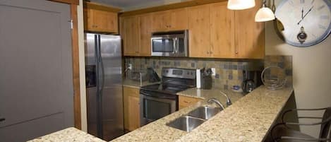 Immaculate full kitchen with stainless steel appliances and granite countertop