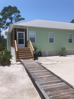 Block patio to right of steps & stepping stones to storage/deck box on left.