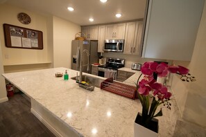 Oversized quartz kitchen countertop. Fridge with water and ice dispenser.