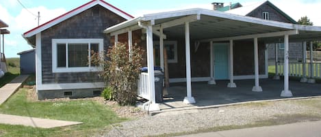 The front of the cottage, showing ample uncover parking for two cars and bikes.