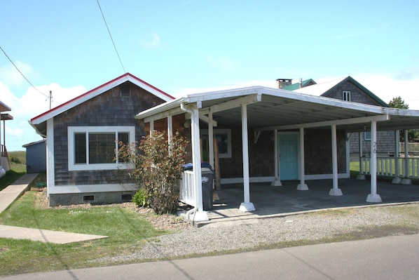 The front of the cottage, showing ample uncover parking for two cars and bikes.