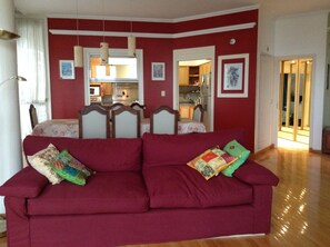 Living room, dining room, and kitchen in the background.