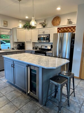 Large quartzite island with Viking beverage fridge and room for seats.
