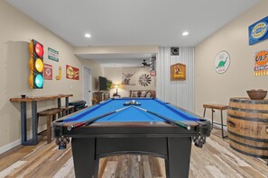 Get ready for non-stop fun in this one-of-a-kind vintage-style game room! Shoot pool beneath retro gas station signs, challenge your crew to darts, cornhole, or a friendly card game, and soak in the nostalgic vibes with a unique traffic light centerpiece. When you're ready to unwind, head outside to your private luxury Jacuzzi tub under the stars—perfect for ending the day in t...