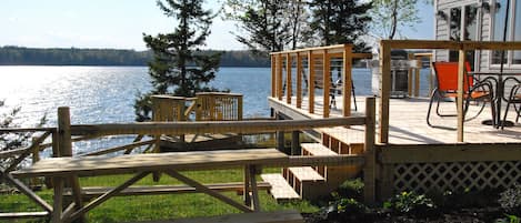 Deck with grill, seating, steps to fenced yard, steps to shore, picnic table