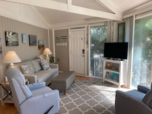 Smart TV in the open living room with floor to ceiling windows.
