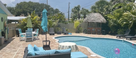 Large fenced yard with heated private pool, tiki bar, lounging fire pit and more