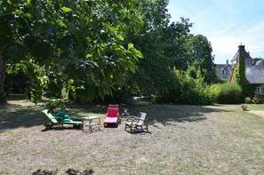 Partie du jardin et mare derrière les transats