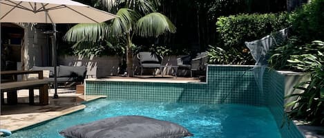 Outdoor pool & dining area surrounded by lush bamboo