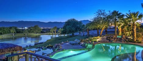 View of private lake with mountain views from bridge over pool. 