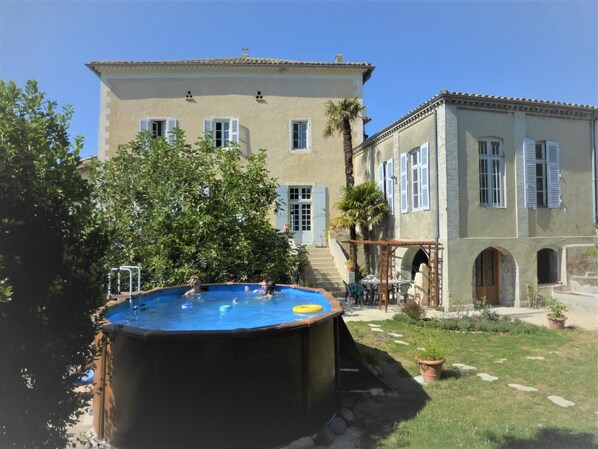 le jardin et la piscine hors sol; au fond la maison, sa façade en plein sud.