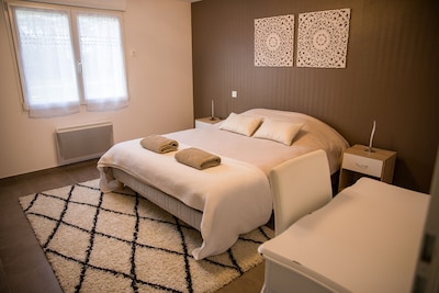 Chambre marron avec lit double 160 * 200 cm, bureau et penderie.