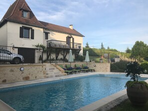 Secure fenced pool with loungers.
