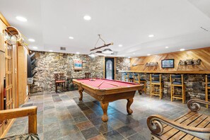 The game room features a pool table, tv, 18ft bar, ring toss game, & boot warmer