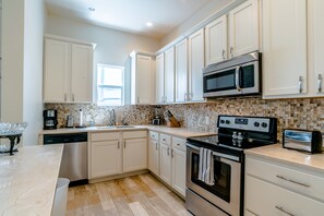 New upscale kitchen equipped for cooking, granite countertops, stainless.