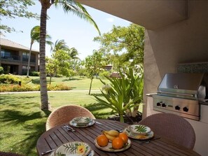 Outdoor patio with gas grill and  a view out toward the pool