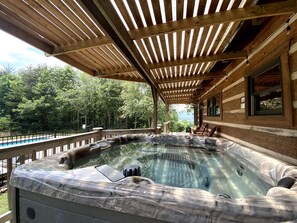 Our large hot tub under the covered porch, overlooks the gated swimming pool. 