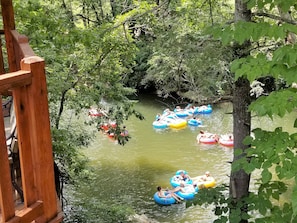 Join in the fun with happy tubers floating  by on the river just below the decks