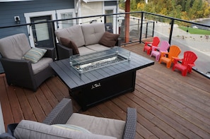 Front deck with fire table, kids chairs and seating. 