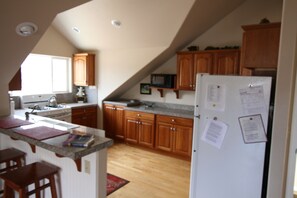 fully equipped kitchen w/granite countertops, wood floors
