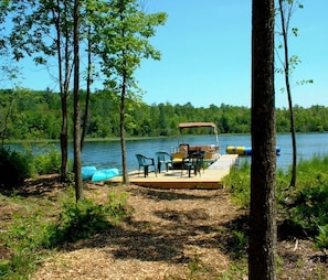 Private water frontage with fire pit, pontoon boat and kayaks.