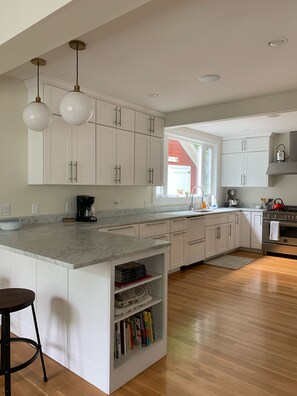 Kitchen with counter seating, bertazzoni range, dishwasher, microwave
