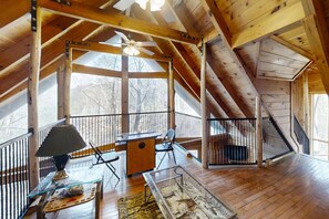 High ceilings, tree trunk beams, and an arcade machine fit for anyone here in the loft.