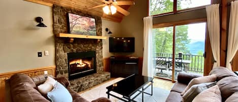 The Spacious Living Room Offers Incredible Views, Native Stone Fireplace, and a Wall of Glass to take in the Long Range Views