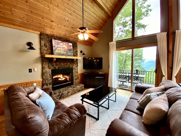 The Spacious Living Room Offers Incredible Views, Native Stone Fireplace, and a Wall of Glass to take in the Long Range Views