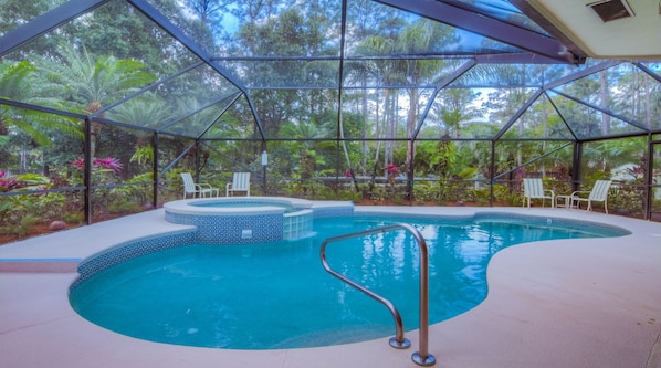 The heated pool and spa are screened and surrounded by lush tropical landscaping
