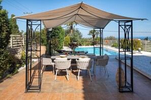 Shaded dining table and seating area by the pool!