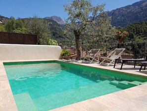 A private saltwater pool with 5 sun beds and 2 chairs and a small coffee table.