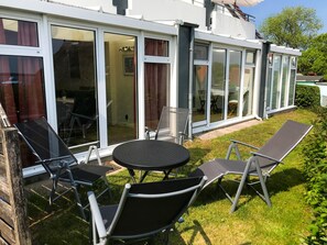 Der Garten mit Meerblick, Sitzgelegenheiten und Liegestühlen.