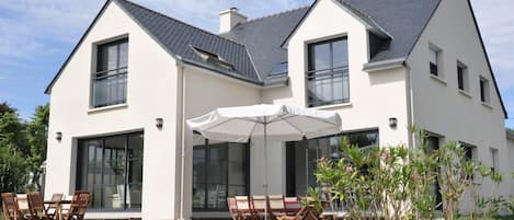 La maison, lumineuse, plein sud, donne sur une grande terrasse en bois