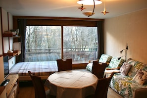 Vue de la table, lit, deux fauteuils et canapé convertible