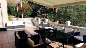 Terrasse côté sud avec store roulant et vue sur piscine 