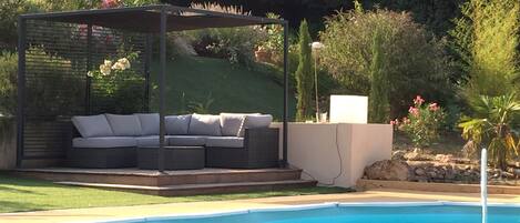 Terrasse en bois exotique avec salon confortable et frigo piscine
