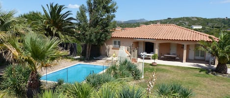 Vue générale de la maison, du jardin et de la piscine.