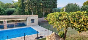 La piscine entièrement sécurisée, le pool house vus depuis le perron